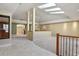 Open-concept living room with skylights, carpet, pillars, and partial walls with views to the kitchen at 5460 S Locust St, Greenwood Village, CO 80111