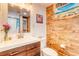 Bathroom featuring wood-look tile walls, modern vanity, and a unique poster at 6742 Flower St, Arvada, CO 80004