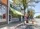 Exterior view of Sweet Action Ice Cream shop with a green awning and street-side seating at 1 S Pennsylvania St # 102, Denver, CO 80209