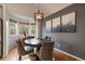Elegant dining area with a round wood table, and eye-catching modern lighting fixture at 11785 W Belleview, Littleton, CO 80127