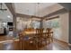 Bright dining room featuring hardwood floors, a modern light fixture, and view of the fireplace in the living room at 11785 W Belleview, Littleton, CO 80127