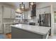 Modern kitchen featuring stainless steel appliances, a center island, white cabinets, subway tile backsplash, and pendant lighting at 11785 W Belleview, Littleton, CO 80127