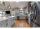 Stylish kitchen with stainless steel appliances, a large island, white cabinetry, and hardwood floors at 11785 W Belleview, Littleton, CO 80127