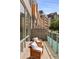 Image shows an outdoor balcony with seating and glass railings, with an exterior view of a brick building at 1644 Little Raven St, Denver, CO 80202