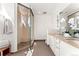 Bright bathroom featuring a glass-enclosed shower, double sink vanity, and neutral tile flooring at 1644 Little Raven St, Denver, CO 80202