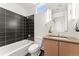 Modern bathroom with dark tile shower, light wood vanity, and sleek fixtures at 1644 Little Raven St, Denver, CO 80202