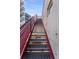 Image shows the staircase with red railings and concrete walls leading to the rooftop in the building at 1644 Little Raven St, Denver, CO 80202
