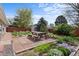 A beautiful backyard with a brick patio, a picnic table, and landscaping at 1650 Bedivere Cir, Lafayette, CO 80026