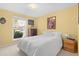 A serene bedroom featuring yellow walls, a large window, and a comfortable bed with white bedding at 1650 Bedivere Cir, Lafayette, CO 80026