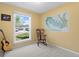 Light filled bedroom with yellow walls, featuring a guitar, a chair and a large window at 1650 Bedivere Cir, Lafayette, CO 80026