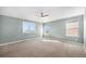 Spacious bedroom with neutral carpet, three windows, and ceiling fan at 21383 E Smoky Hill Rd, Centennial, CO 80015