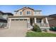 Two-story home with tan siding, stone accents, covered porch, and attached two-car garage at 21383 E Smoky Hill Rd, Centennial, CO 80015