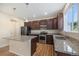 Bright kitchen with granite counters, stainless steel appliances, wood floors and dark wood cabinets at 21383 E Smoky Hill Rd, Centennial, CO 80015
