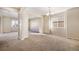 Bright open-concept living room with neutral carpet, chandelier, and ample natural light at 21383 E Smoky Hill Rd, Centennial, CO 80015