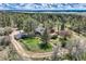 Spacious aerial view of a property surrounded by mature trees and lush greenery, offering a serene and private setting at 7715 Rafter Rd, Franktown, CO 80116
