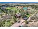Stunning aerial view of a home with a red roof, garage, and RV parking nestled amidst lush trees and open land at 7715 Rafter Rd, Franktown, CO 80116
