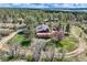 Aerial view of a home surrounded by lush trees, featuring a chimney, covered area, and well-maintained grounds at 7715 Rafter Rd, Franktown, CO 80116