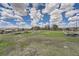 Backyard view showing an empty field with green grass and a clear blue sky with white clouds at 7715 Rafter Rd, Franktown, CO 80116