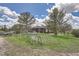 View of the home's rear exterior, showing a fenced yard and plenty of trees at 7715 Rafter Rd, Franktown, CO 80116