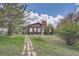 Charming home with brick accents, surrounded by mature trees and a brick walkway, set in a tranquil, green landscape at 7715 Rafter Rd, Franktown, CO 80116