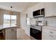 Bright kitchen featuring white cabinets, stainless steel appliances, and modern finishes at 34544 Columbine W Trl, Elizabeth, CO 80107