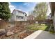 Spacious fenced backyard with a stone garden, green lawn, and patio area at 9640 Sydney Ln, Highlands Ranch, CO 80130