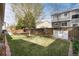 A well-maintained backyard featuring lush grass, mature trees, and a privacy fence at 9640 Sydney Ln, Highlands Ranch, CO 80130