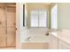 Bright bathroom featuring a glass enclosed shower, large tub, and bright window at 9640 Sydney Ln, Highlands Ranch, CO 80130
