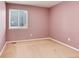 Small bedroom with rose colored walls, carpet, and a large window with blinds at 9640 Sydney Ln, Highlands Ranch, CO 80130