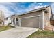 Tan home featuring a two-car garage, neutral-toned siding, and well-maintained lawn at 9640 Sydney Ln, Highlands Ranch, CO 80130