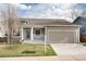 Charming home featuring a two-car garage, well-maintained lawn, and neutral-tone siding at 9640 Sydney Ln, Highlands Ranch, CO 80130
