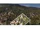 High-angle view of a home surrounded by lush forest, showcasing the property boundary at 32187 Sylvan Rd, Golden, CO 80403