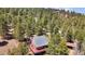 Aerial view of a cozy house surrounded by lush trees, complete with a spacious deck at 32187 Sylvan Rd, Golden, CO 80403