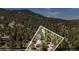 Aerial view of a home nestled in a lush forest, with property lines marked for clarity at 32187 Sylvan Rd, Golden, CO 80403