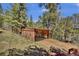 Carport and parking area surrounded by pine trees at 32187 Sylvan Rd, Golden, CO 80403