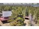 Charming exterior view of a two story home with a large deck surrounded by trees, perfect for nature lovers at 32187 Sylvan Rd, Golden, CO 80403
