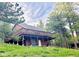 Mountain home on a lush green hillside with a large wooden deck and a carport nearby at 32187 Sylvan Rd, Golden, CO 80403