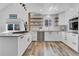 Bright kitchen featuring white countertops, open wooden shelves, modern appliances, and lots of natural light at 32187 Sylvan Rd, Golden, CO 80403
