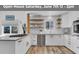 Bright kitchen featuring white cabinets, stainless steel appliances, and wood floating shelves at 32187 Sylvan Rd, Golden, CO 80403