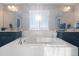 Beautiful bathroom featuring a large soaking tub with bright sunlight and white tile work at 1721 Wingfeather Ln, Castle Rock, CO 80108