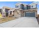 Charming two-story home featuring a stone facade, gray siding, and an attached two-car garage at 1721 Wingfeather Ln, Castle Rock, CO 80108