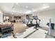 Open-concept home gym with carpeted flooring, modern equipment, and easy access to kitchen at 1721 Wingfeather Ln, Castle Rock, CO 80108