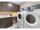 Laundry room includes front load washer and dryer, utility sink, and storage cabinets at 1721 Wingfeather Ln, Castle Rock, CO 80108