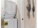 Efficient white stacked washer and dryer, maximizing laundry space in a neutral-toned room with decorative wall art at 4588 S Versailles St # B, Aurora, CO 80015