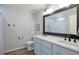 Bathroom with double vanity, dark fixtures, white quartz countertop, and a large mirror at 1017 Mircos St, Erie, CO 80516