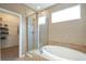 Bathroom featuring a glass-enclosed shower, bathtub, and tile accents with a view into a walk-in closet at 1017 Mircos St, Erie, CO 80516
