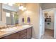 Bathroom featuring double sinks, a large mirror, tiled backsplash, plus a door to a walk-in closet at 1017 Mircos St, Erie, CO 80516