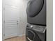 Modern laundry room features a stacked washer and dryer and door to the exterior at 1017 Mircos St, Erie, CO 80516