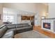 Open-concept living room with a cozy fireplace, hardwood floors, and modern furnishings at 1017 Mircos St, Erie, CO 80516