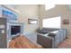 Bright living room with fireplace, hardwood floors, large windows, and comfortable gray leather sectional sofa at 1017 Mircos St, Erie, CO 80516
